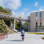 Student riding a bike through campus