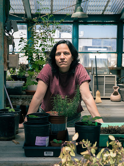 Female scientists stands with various plants