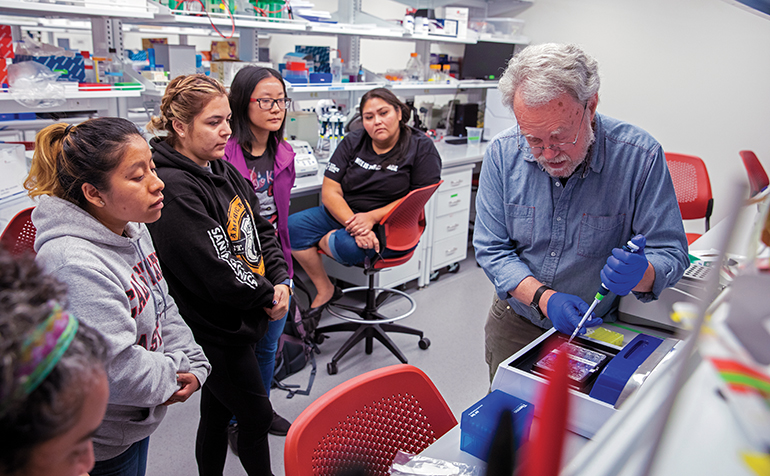 Chris Baysdorfer works with students in lab