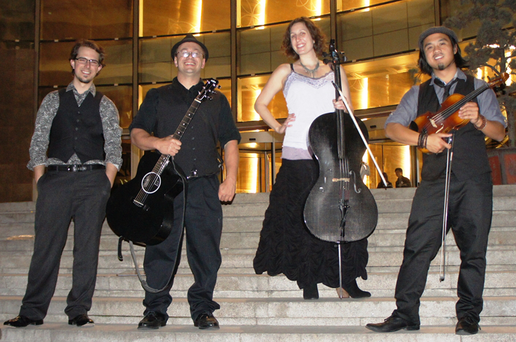 the musical group Dirty Cello standing on the outside stairs of a concert hall.