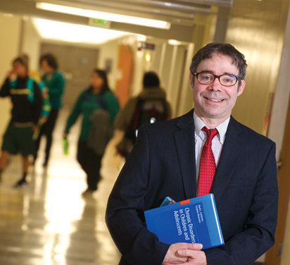 Dr. Stephen Morewitz in a school hallway.