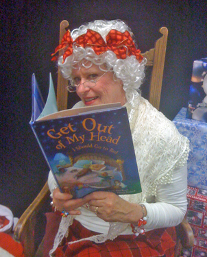 CSUEB alumna Susan Pace-Koch dressed as Mrs. Claus while she read from her first children's book, "Get Out of My Head, I Should Go to Sleep".