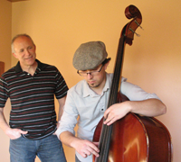 Man with son who is playing the string bass.