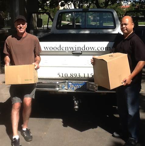 Dr. Lee and Vince Ang standing in front of a pick-up truck loaded with boxes of donated of textbooks.
