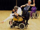 Picture of man in wheelchair dancing with woman who is on her feet.