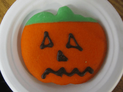 Cookie decorated like a pumpkin.