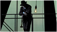 Silhouette of trumpeter dressed in suit, dress hat.