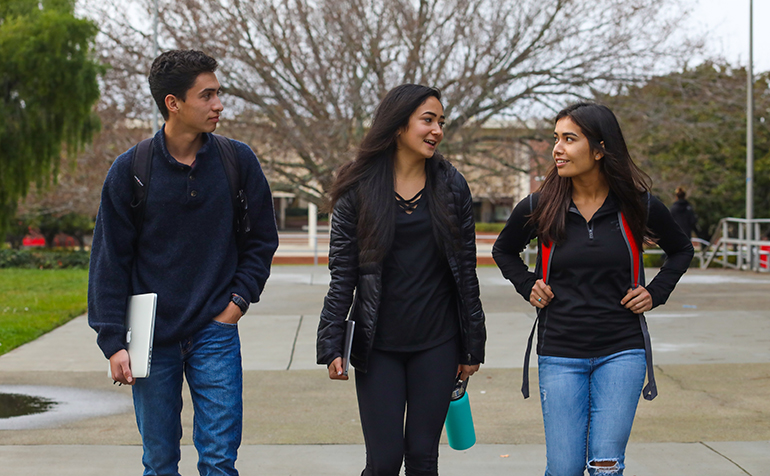 Three students walking on campus