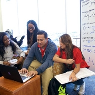 Four students work on a project in the library
