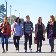 A diverse group of students walks through campus