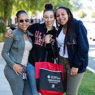 Three young women smile and pose for the camera