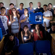 A group of students hold lightbulbs