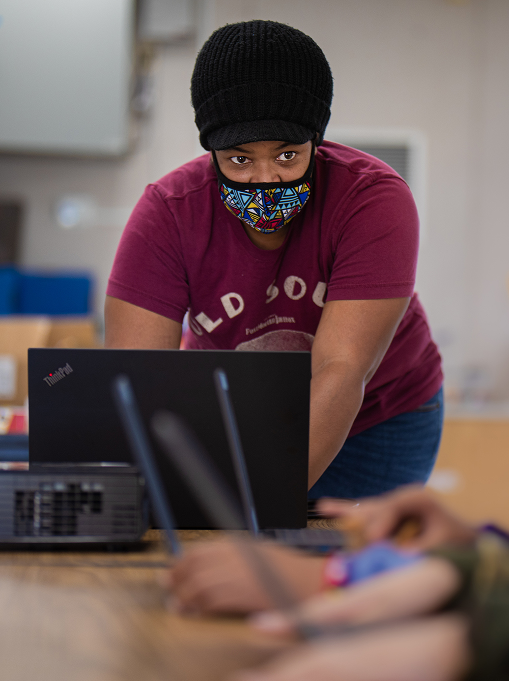 Teacher in mask with computer in front of her