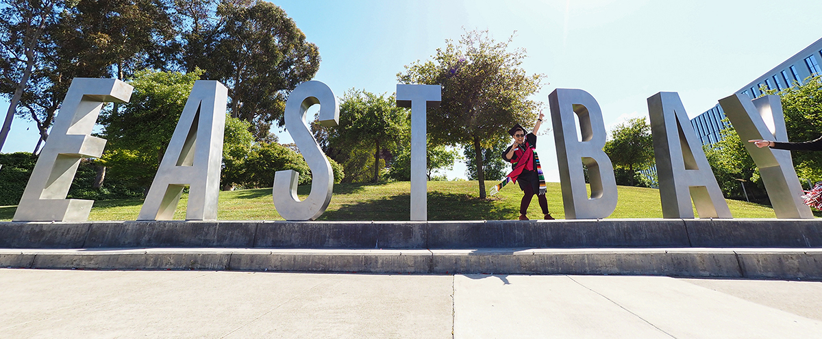 Graduate celebrates at East Bay sign