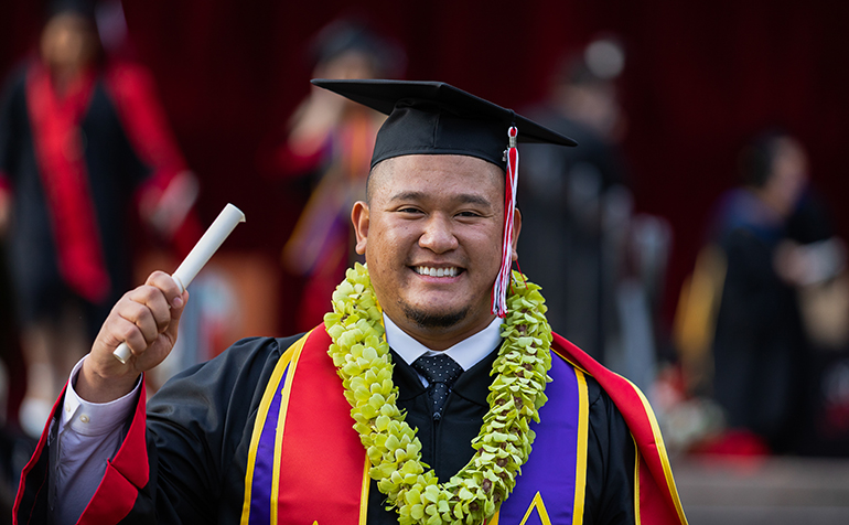 Student holds diploma at graduation