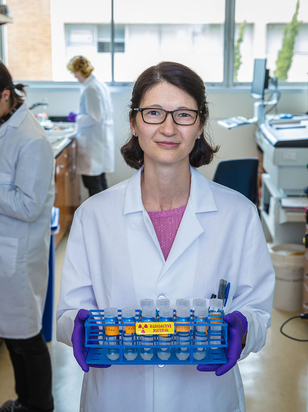 Scientist holds up tray of test tubes