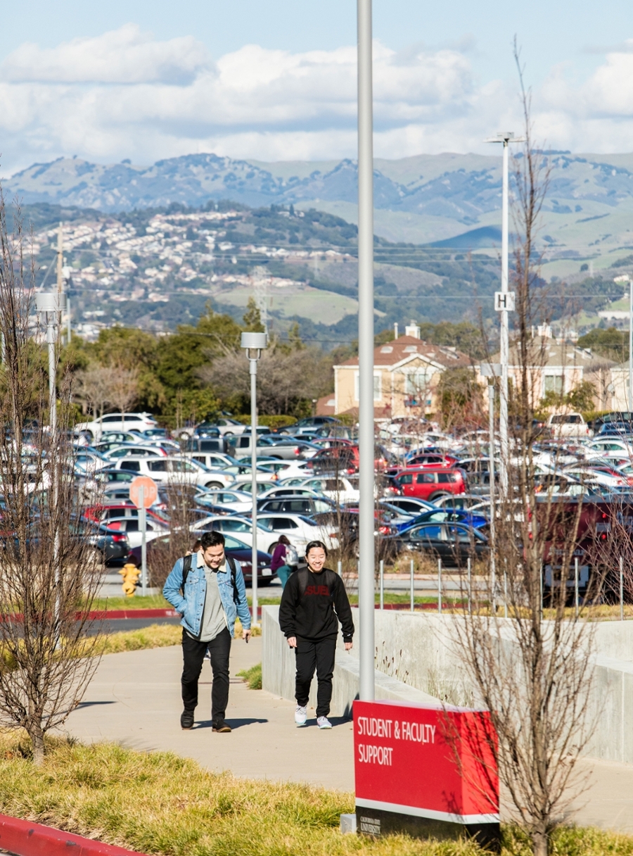 Hills as students walk past big white building