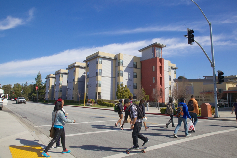 Students cross the street in front of Pioneer Heights dorms