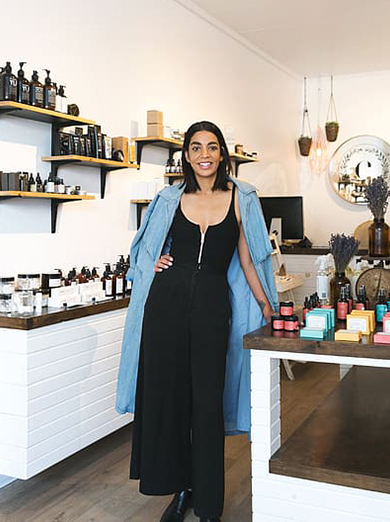 Woman stands with items from her small business