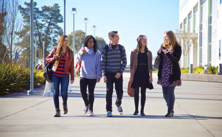 5 students are walking on campus