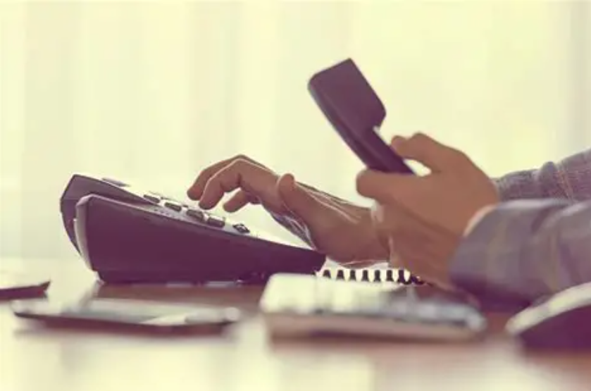 Hand picking up a telephone