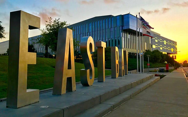 The East Bay monument letters with the SA building in the background at sunset