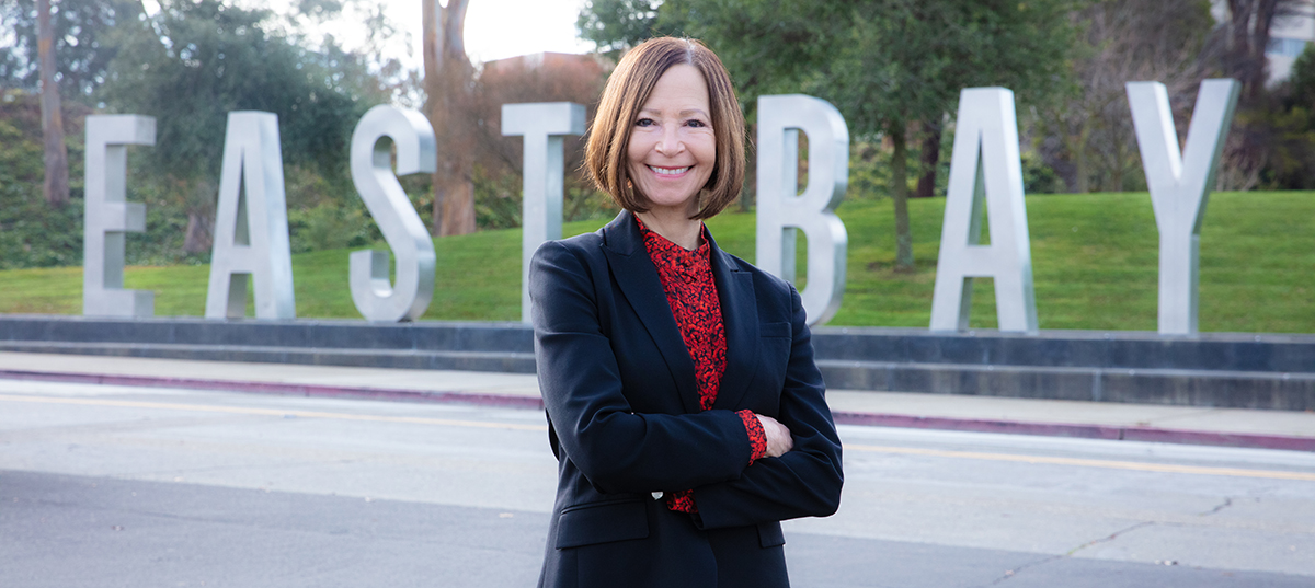 President Cathy Sandeen in front of East Bay monument letters