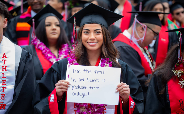Student at commencement holding up sign