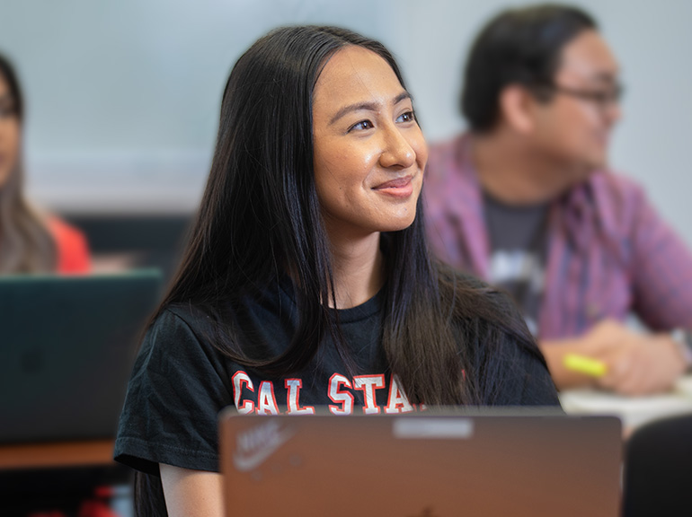 Female student with a laptop in a classroom