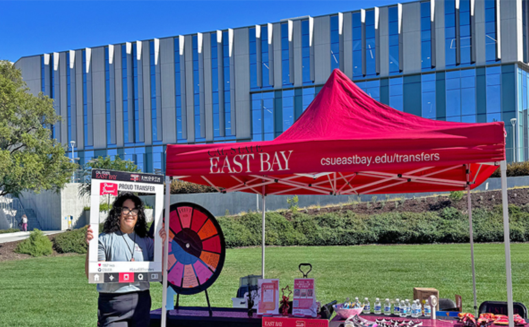 Transfer Student standing in front of the Transfer Students Booth