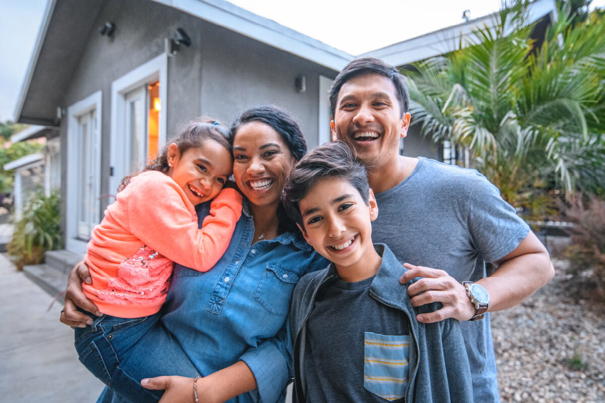 a family of four in front of a house