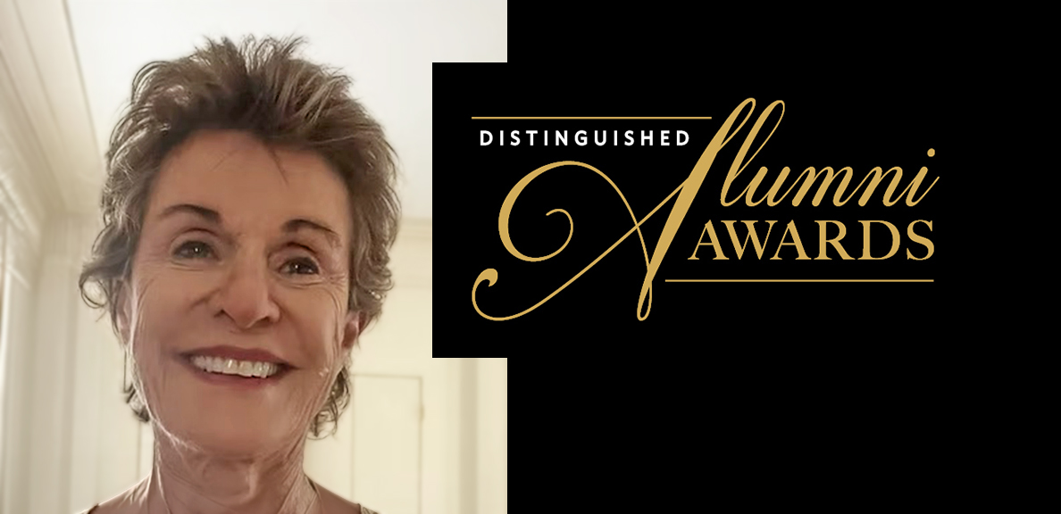 A women Smiling at the camera with "Distinguished Alumni Awards" next to her  
