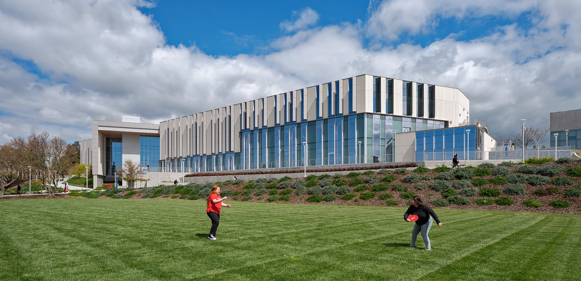Students playing frisbee on the lawn in front of the CORE building