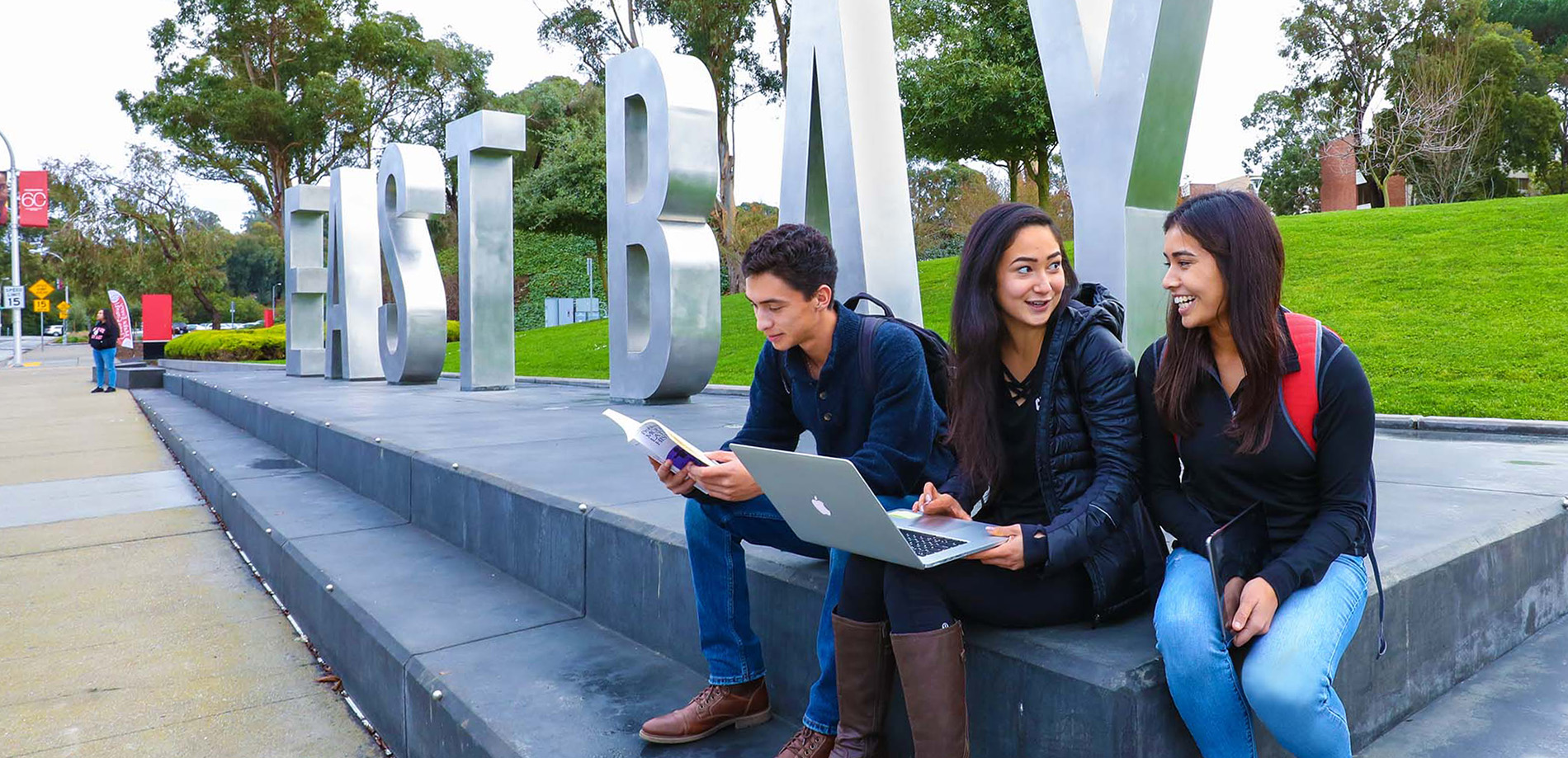 Students sitting in front of big east bay letters