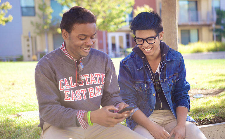 Two students sitting and smiling