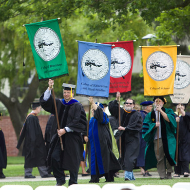 Faculty Members holding the college flags