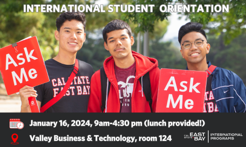 3 students, 2 with "Ask me" signs at orientation