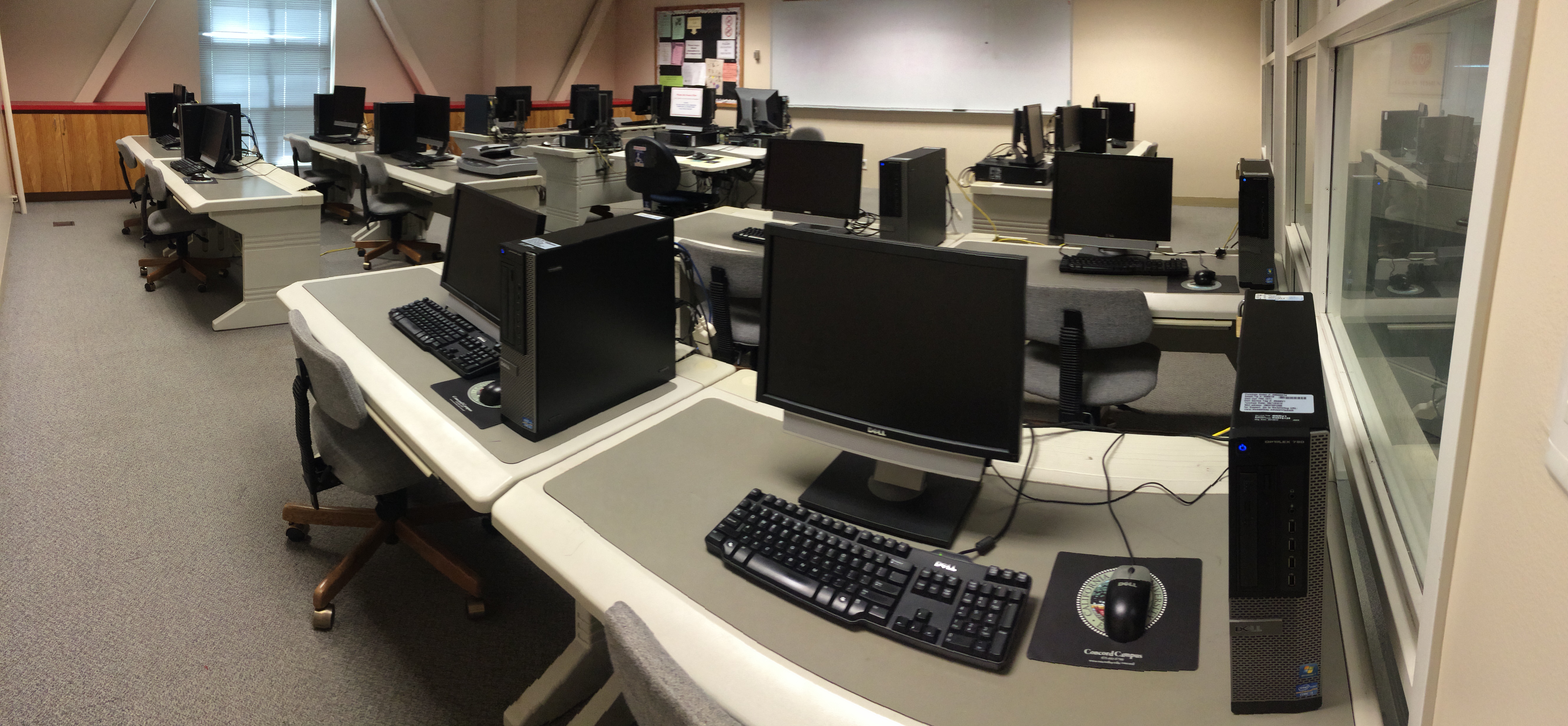 Computers lined up with chairs in the lab