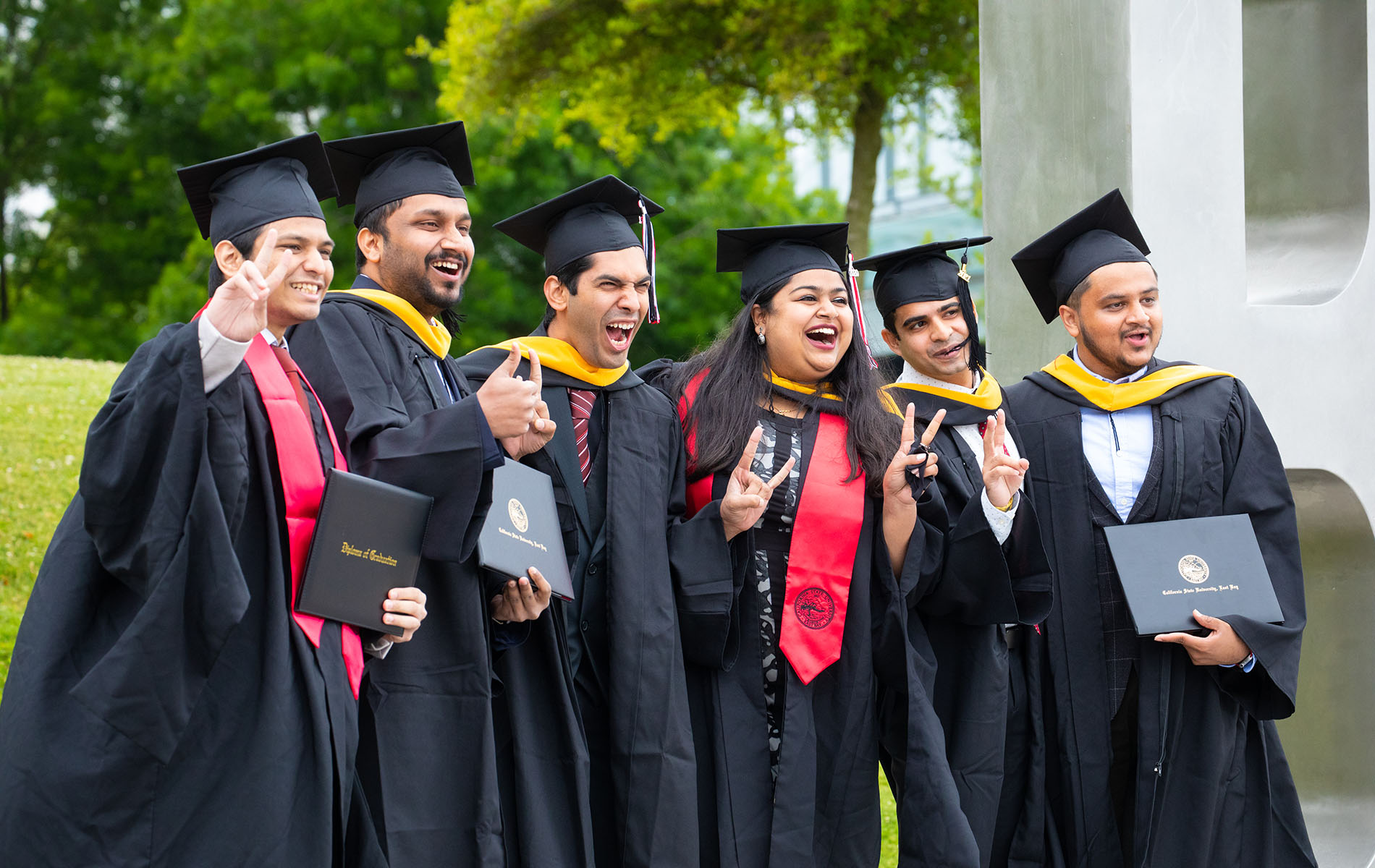 Group of graduates celebrate holding diploma