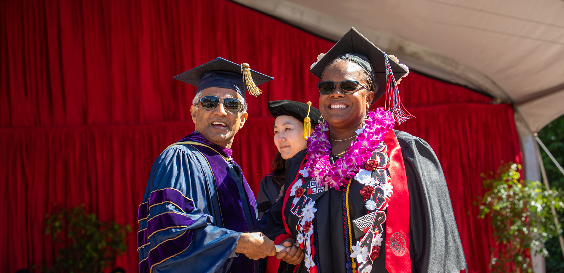 Graduate and a faculty member shaking hands