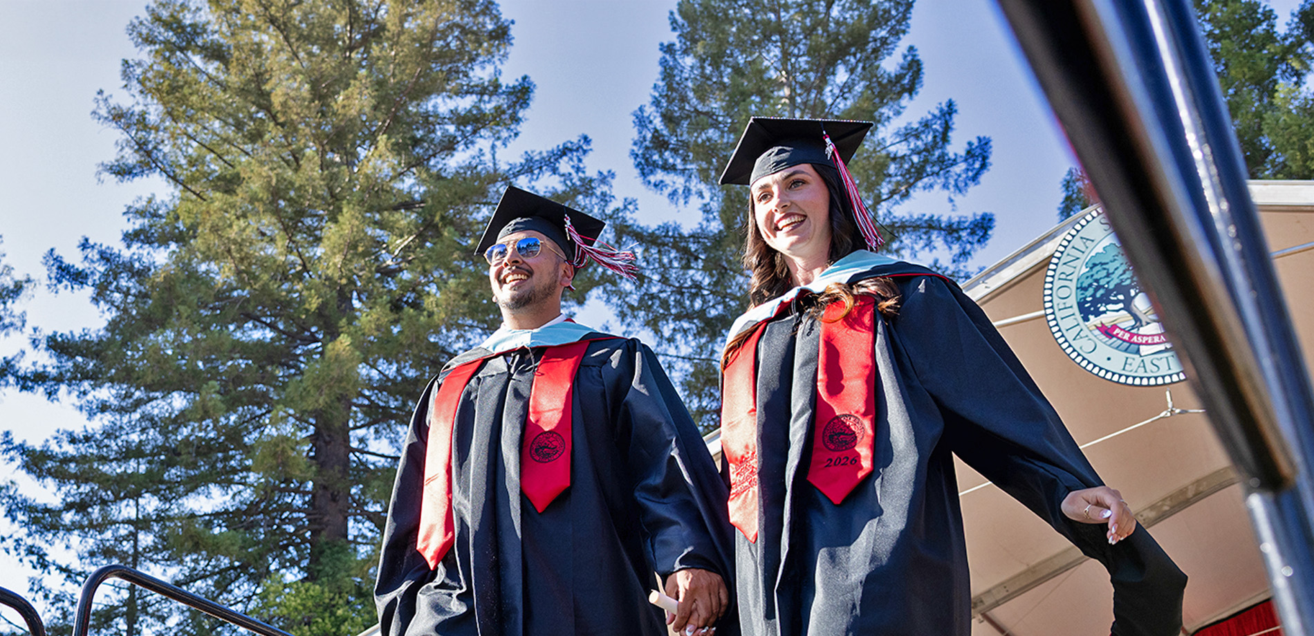 Two graduates walking down the amphitheater steps