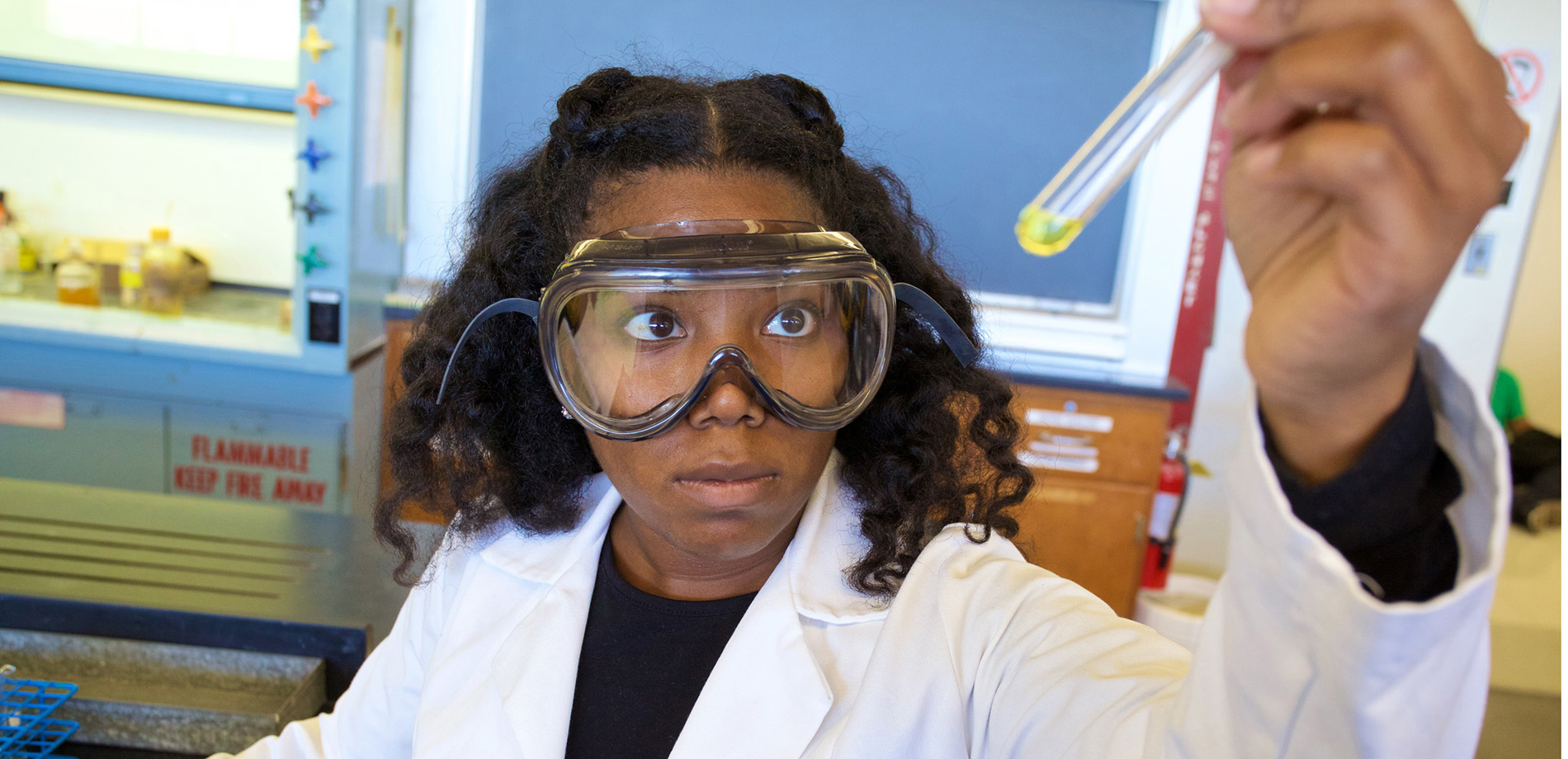 Girl looking at test tube in lab.