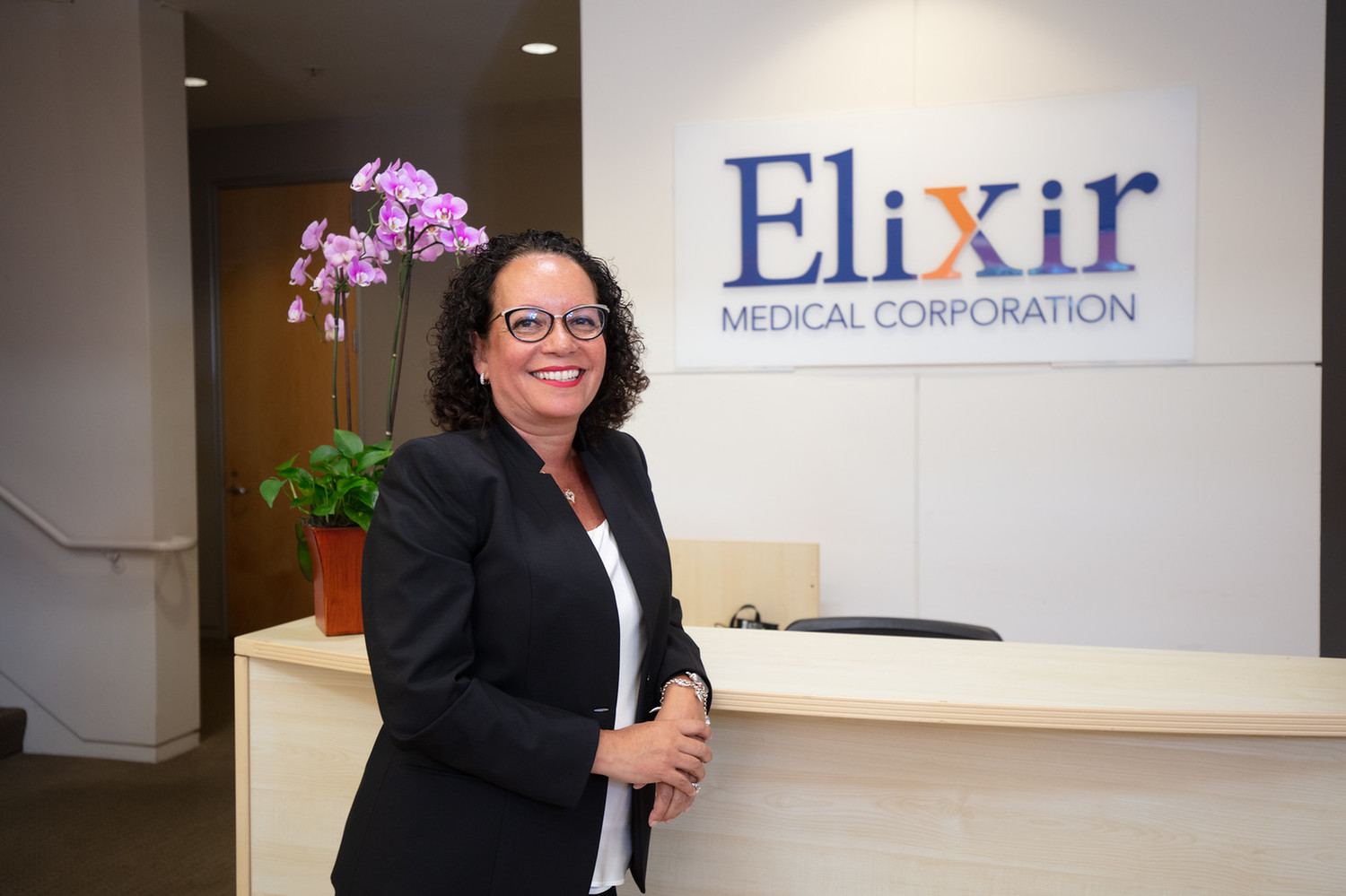 Sara Toyloy smiling at the front desk of Elixir Medical Coporation