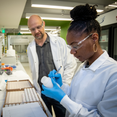 a student pipetting liquids while being supervised