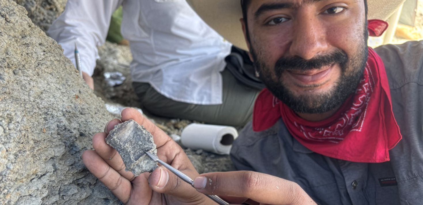Graduate student Trinidad Cruz hold a fossil vertebra.