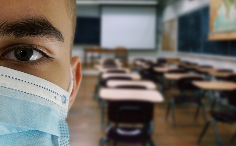 Student with mask in an empty classroom.