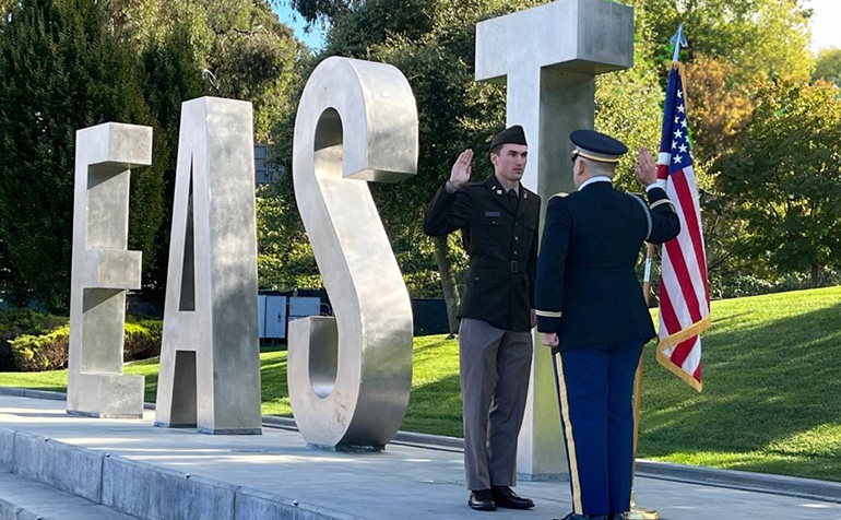 Military member in front of East Bay Letters 
