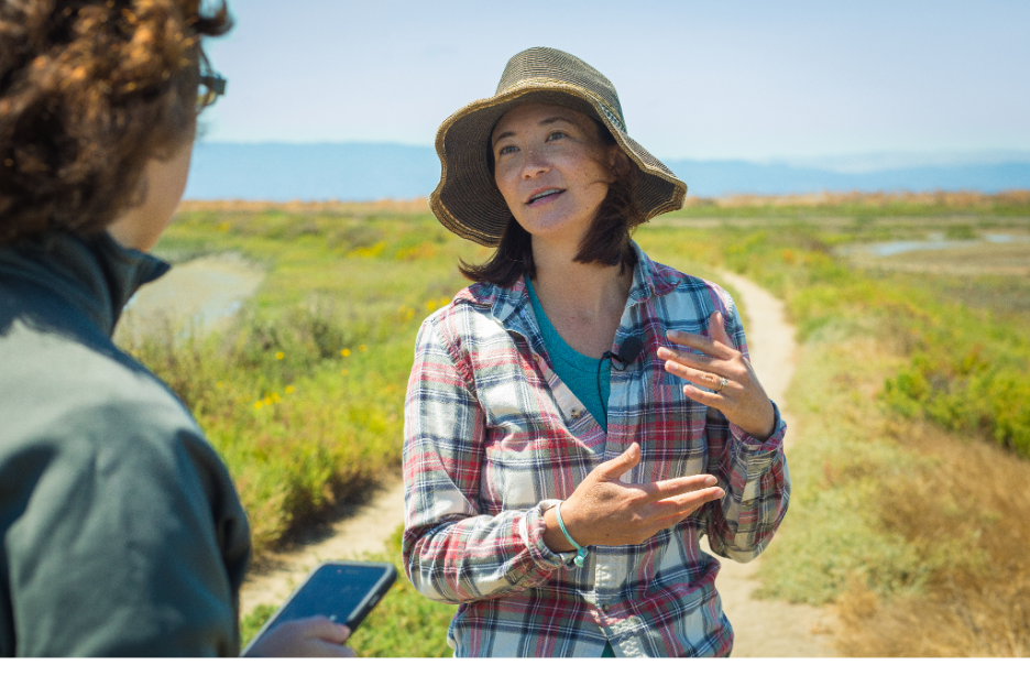 Image depicts Dr. Patty Oikawa, Faculty member talking to a colleague in the field.