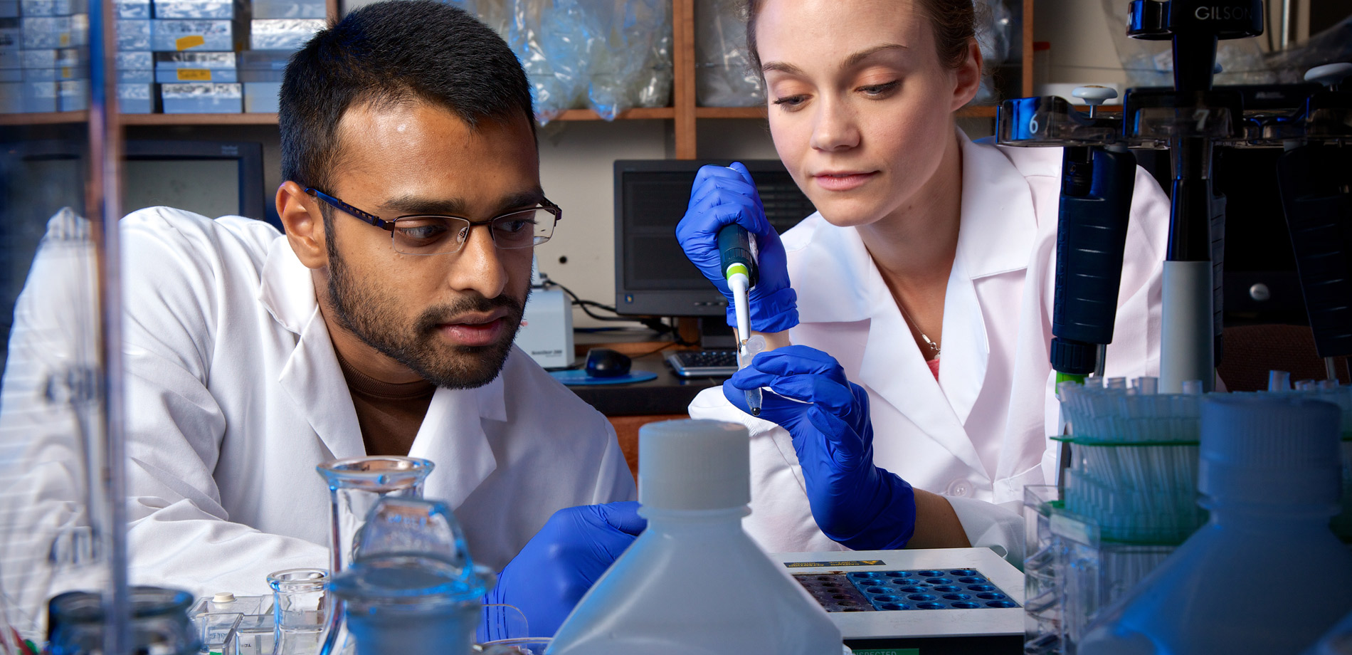 Two Students Filling a Vial With Liquid