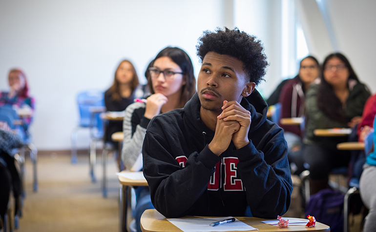 Male student looking inquisitively in classroom